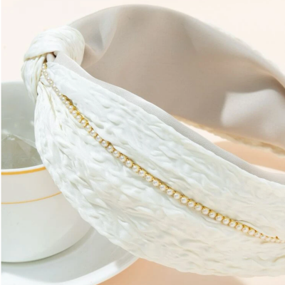 عصابة رأس باللونين الأبيض والذهبي